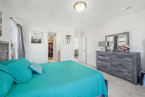 Carpeted bedroom with multiple windows