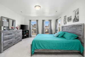 Bedroom featuring light carpet and multiple windows