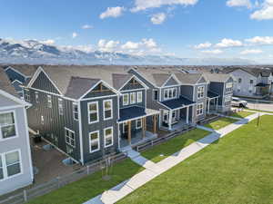 View of front of property featuring board and batten siding, a residential view, a shingled roof, central AC, and covered porch