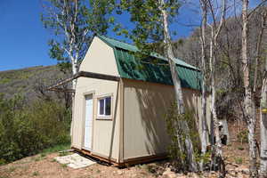 View of 12.5' x 16.5' shed featuring a wooded view