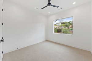 Unfurnished room featuring light colored carpet, a ceiling fan, baseboards, and recessed lighting