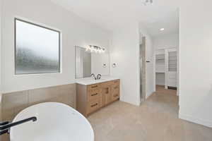 Bathroom featuring a walk in closet, a freestanding bath, vanity, recessed lighting, and tile patterned floors