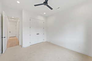 Unfurnished bedroom with light carpet, recessed lighting, baseboards, a closet, and ceiling fan