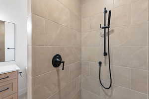 Bathroom view of tiled shower and vanity