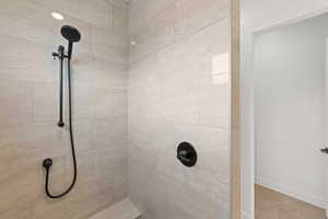 Full bathroom with tiled shower and baseboards