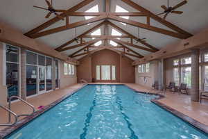 Indoor pool featuring a ceiling fan