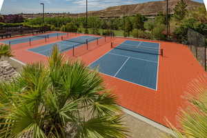 View of tennis court featuring fence, community basketball court, and a mountain view