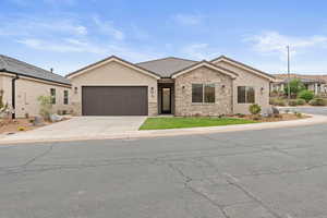 Ranch-style home with stone siding, concrete driveway, a garage, and stucco siding