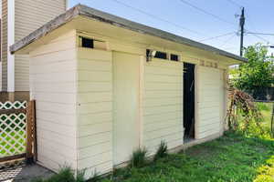 View of outdoor structure with fence and an outdoor structure
