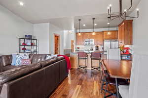 Living room with a chandelier, dark wood-style floors, and recessed lighting