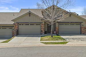 Craftsman inspired home featuring board and batten siding, a shingled roof, a garage, and driveway