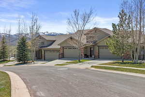 View of front facade featuring driveway, a shingled roof, a mountain view, and a garage