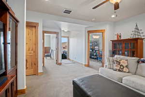 Living area with visible vents, recessed lighting, ceiling fan, light carpet, and baseboards