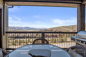 Balcony featuring outdoor dining area and a mountain view