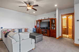 Living area featuring carpet flooring, baseboards, a ceiling fan, and recessed lighting