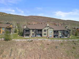 Back of house with a chimney, board and batten siding, a balcony, and a mountain view