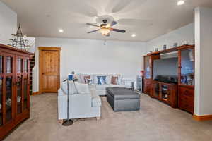 Living area featuring recessed lighting, stairs, a ceiling fan, and carpet floors