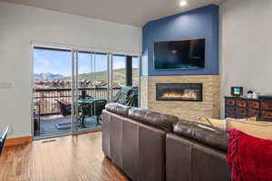 Living room featuring wood finished floors, visible vents, recessed lighting, baseboards, and a stone fireplace