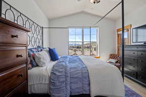 Bedroom featuring wood finished floors and vaulted ceiling
