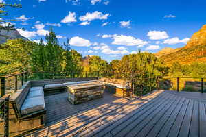 Wooden terrace featuring a mountain view and a fire pit