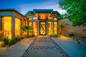 Exterior entry at dusk with stucco siding