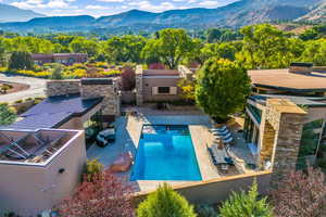 Outdoor pool featuring a mountain view, a patio area, and exterior kitchen