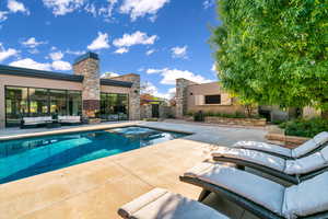 View of pool featuring an outdoor living space, a patio area, and a pool with connected hot tub