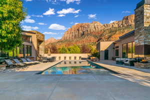 View of swimming pool with outdoor lounge area, a patio area, and a mountain view