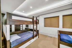 Bedroom with carpet flooring, a tray ceiling, and recessed lighting