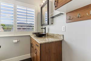 The bathroom features a walk-in shower, sleek fixtures, and bright lighting, blending functionality with a clean, contemporary design.
