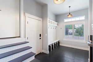 Spacious laundry and mudroom combo featuring convenient garage and ADU access. Includes a built-in drinking fountain, natural light from a large window, and plenty of room to organize shoes, coats, and laundry essentials.