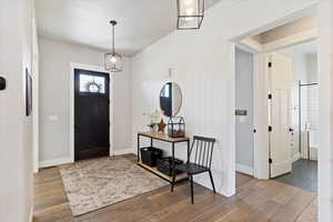 Inviting entryway with warm wood-style floors and towering ceilings, creating a grand first impression and a seamless flow into the main living areas.