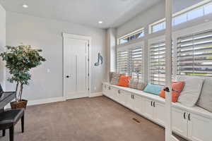 Versatile music room or office with elegant wooden shutters, a built-in window seat with storage, and a closet. Glass doors add a touch of openness while offering privacy when needed.