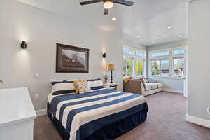 Large main bedroom with a cozy sitting area, tall ceilings, and expansive windows. A serene retreat offering both comfort and style, perfect for relaxation.