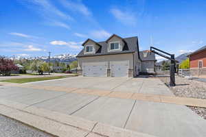 Expansive 3-car garage with a large driveway and a built-in basketball hoop, offering plenty of space for vehicles and recreational activities.
