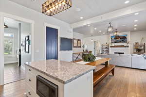 Inviting great room with warm wood-style flooring and recessed lighting.  Just off the great room, a combined mudroom and laundry room adds convenience and functionality.