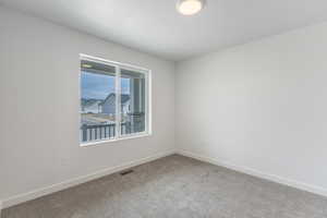 Spare room featuring carpet and baseboards