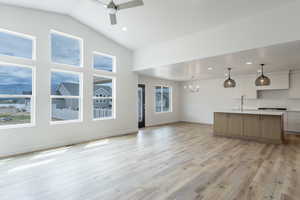 Unfurnished living room with a sink, a chandelier, a ceiling fan, light wood-type flooring, and recessed lighting
