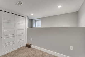 Interior space with baseboards, visible vents, carpet floors, and recessed lighting
