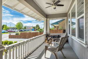 Balcony featuring a ceiling fan, covered porch, and a mountain view