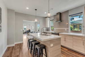 Kitchen with wall chimney range hood, a sink, stainless steel electric range oven, modern cabinets, and recessed lighting