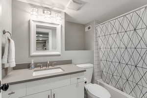 Full bathroom featuring visible vents, toilet, vanity, and shower / tub combo