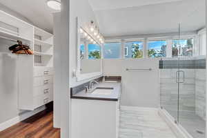 Full bathroom with baseboards, a sink, and a shower stall