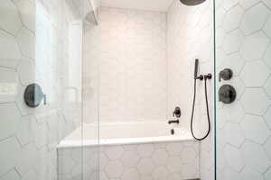 Bathroom with tile walls and tiled shower / bath