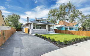 Bungalow with a porch, asphalt driveway, and roof with shingles
