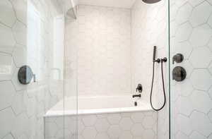 Full bath featuring tile walls