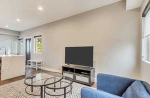 Living area featuring dark wood-style flooring, recessed lighting, and baseboards