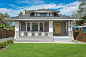 Bungalow-style home with covered porch, a chimney, and roof with shingles