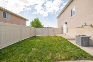 View of yard featuring central air condition unit and a gate