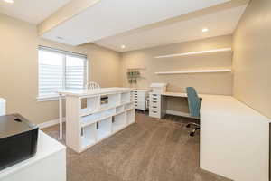Craft room/Bedroom/Office with dark carpet, recessed lighting, baseboards, and built in desk